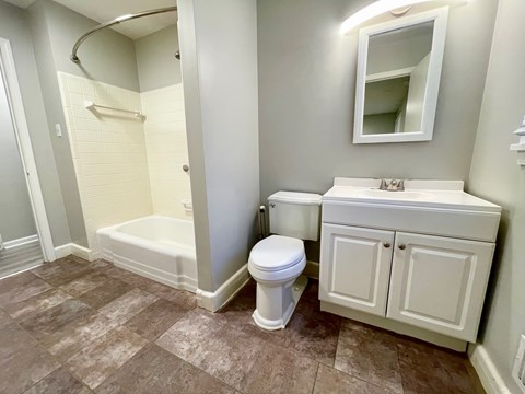 A white toilet sits next to a sink in a bathroom.