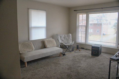 A living room with a grey couch and a chair.