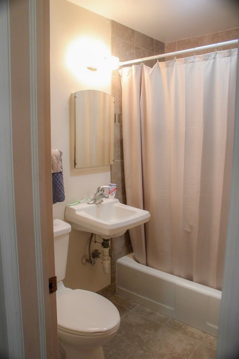 A white toilet sits next to a sink in a small bathroom.