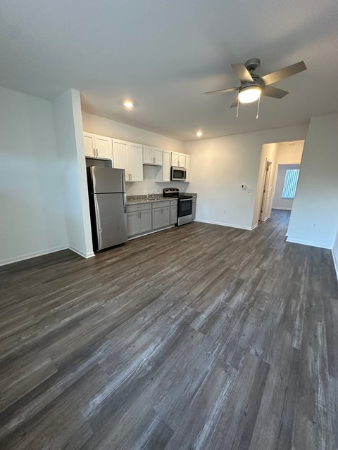 A room with a wooden floor and a ceiling fan.