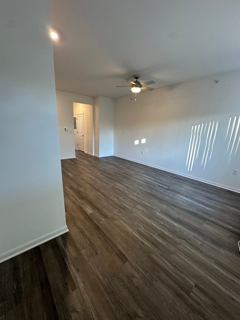 A room with wooden flooring and a ceiling fan.