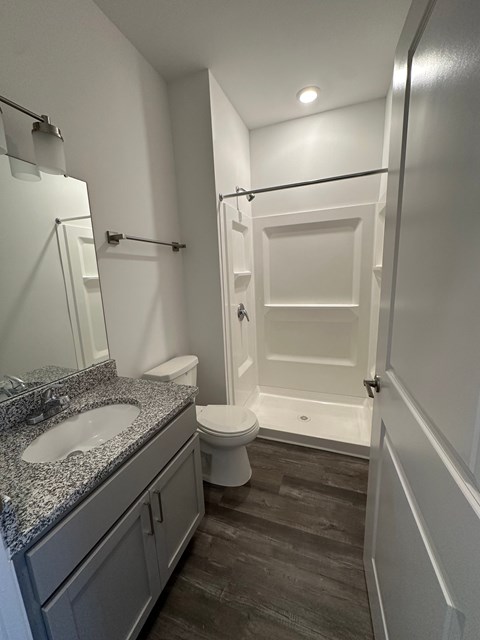 A bathroom with a toilet, sink, and shower.