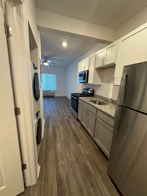 A kitchen with a refrigerator, microwave, and oven.