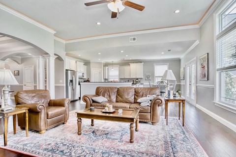 A living room with a brown leather couch and a rug.