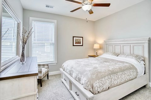 A bedroom with a large bed and a ceiling fan.