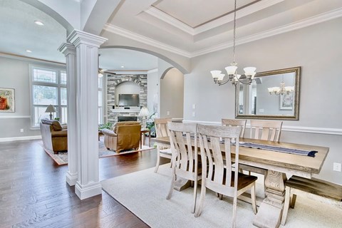 A dining room with a wooden table and chairs.