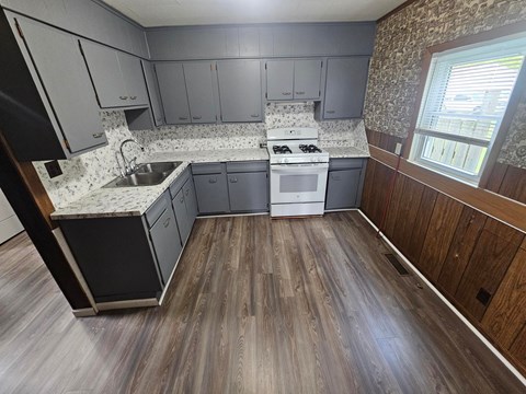 A kitchen with a stove top oven and a sink.