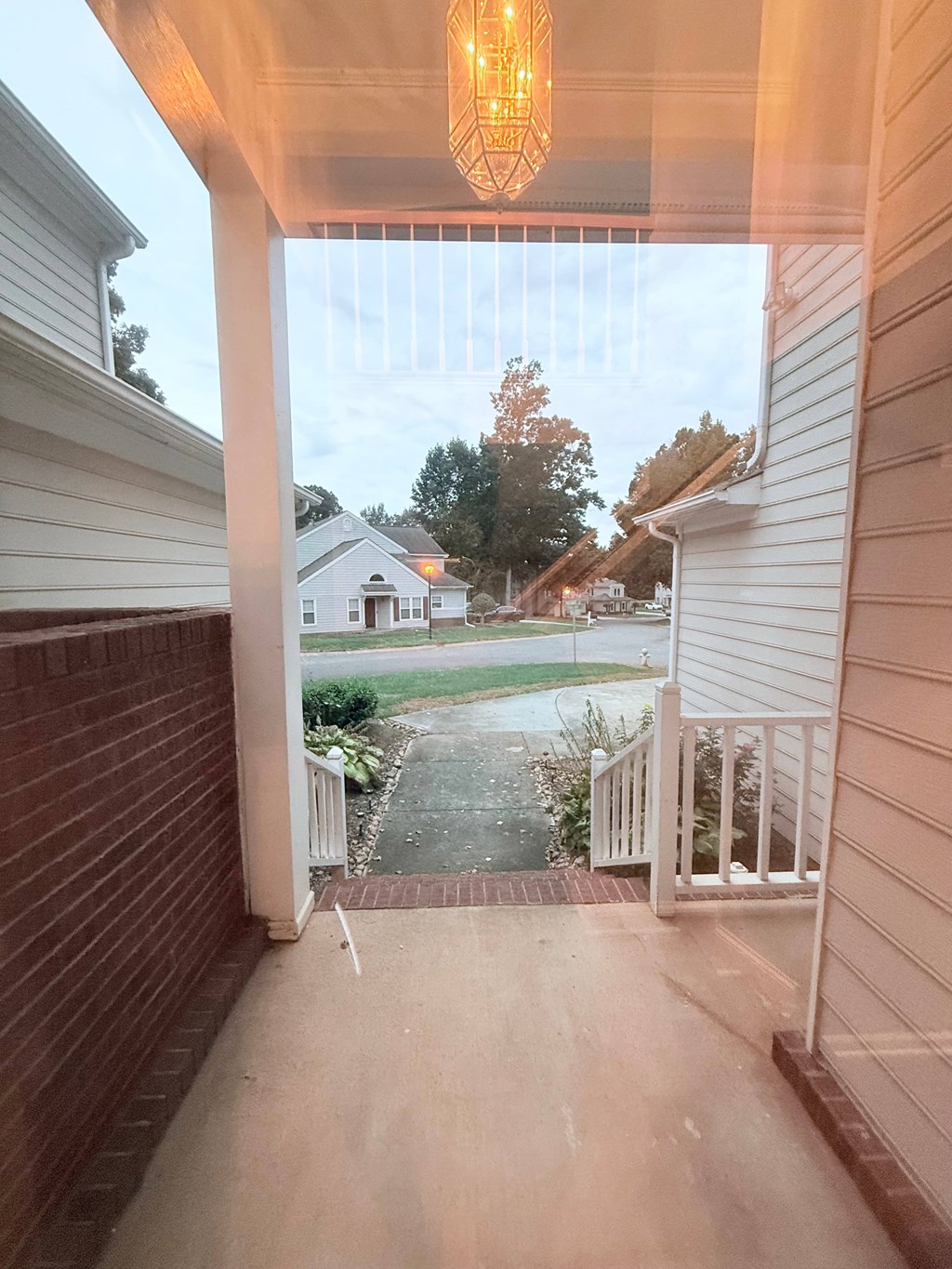A view from a porch looking out to a residential street.