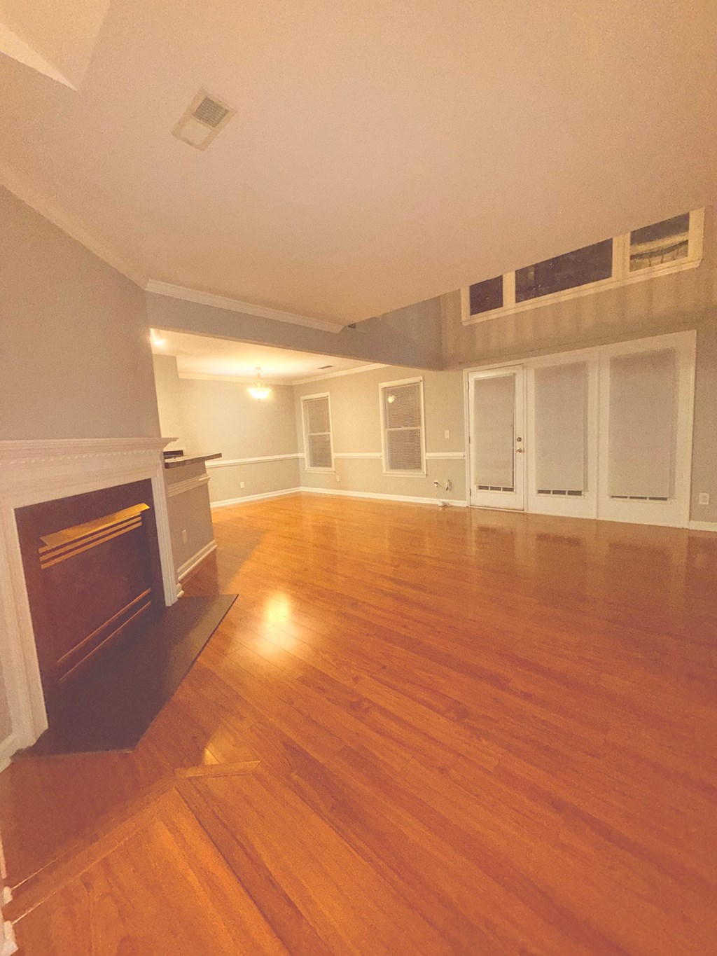 A large empty room with a fireplace on the left side.