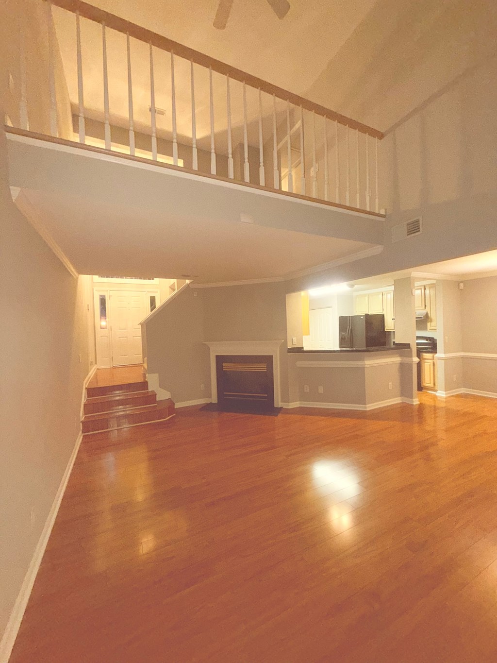 A living room with a fireplace and a staircase.