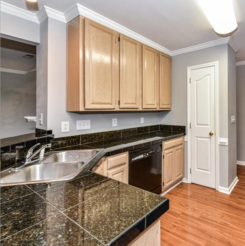 A kitchen with wooden cabinets and a black granite countertop.