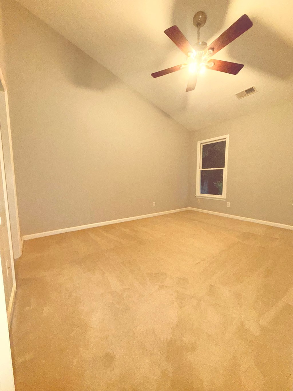 A room with a ceiling fan and a window.