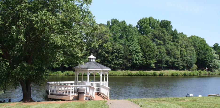 A gazebo sits on a dock by a lake.