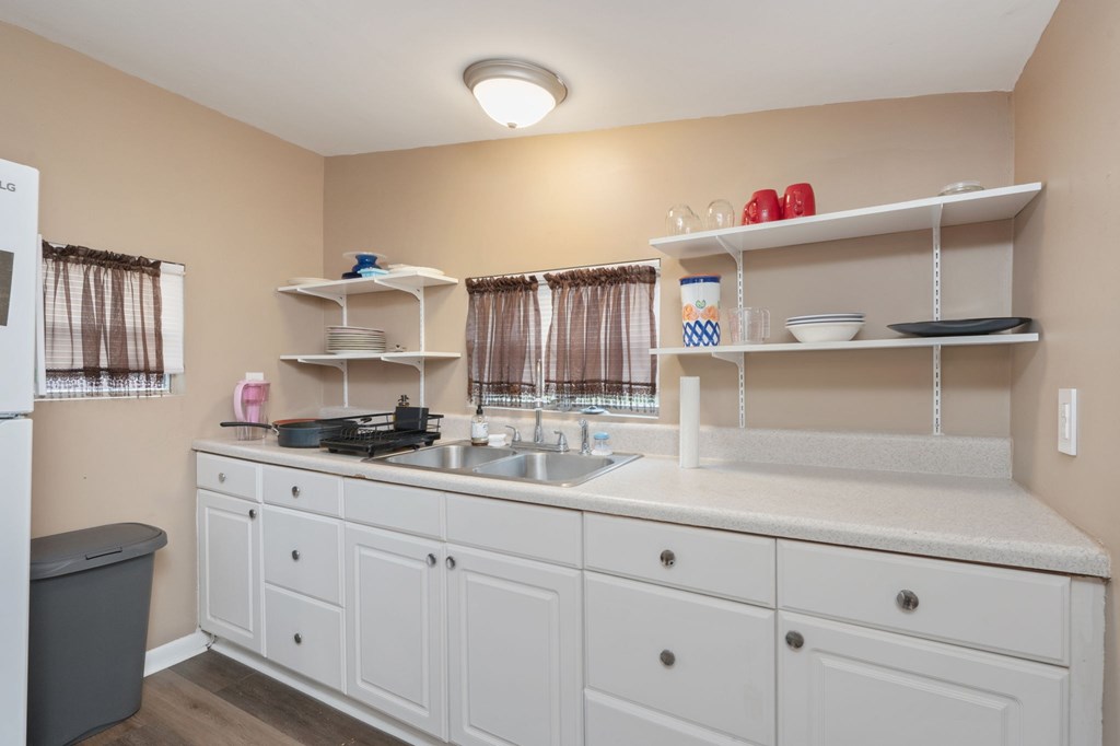 A kitchen with white cabinets and a white countertop.