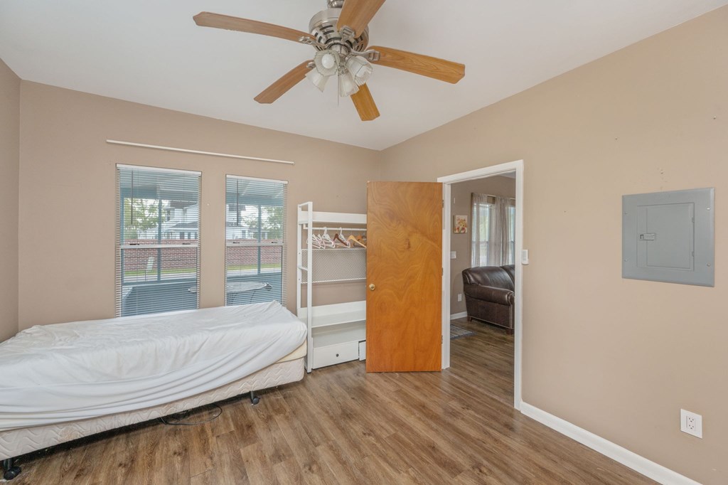 A bedroom with a bed, bunk beds, and a ceiling fan.