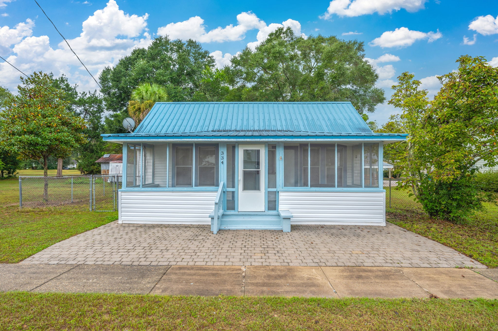 A small house with a blue roof and white walls.