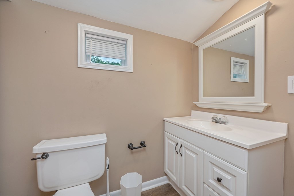 A white toilet sits next to a sink in a small bathroom.