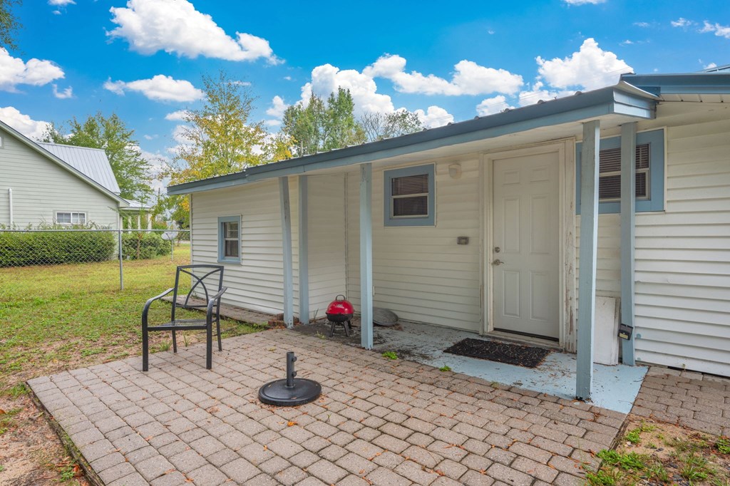 A small house with a white door and a small porch.