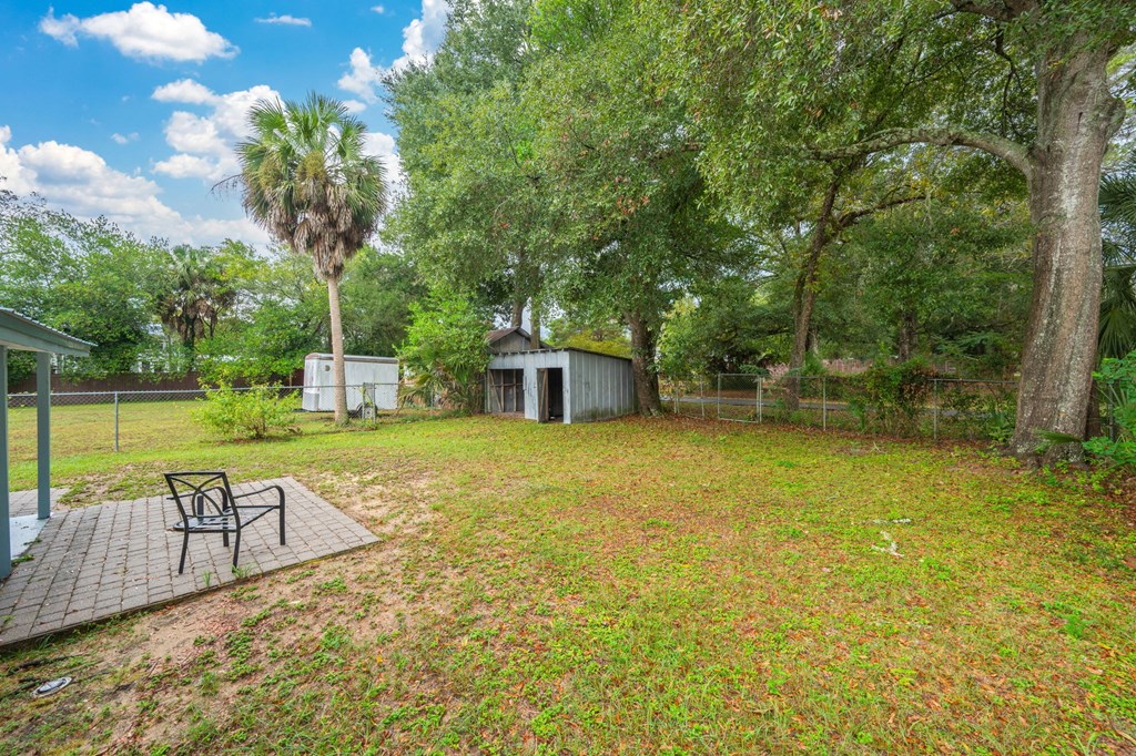 A backyard with a bench and a shed.
