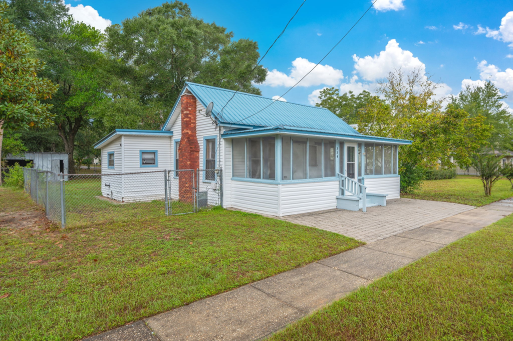 A house with a red brick chimney and a blue roof.