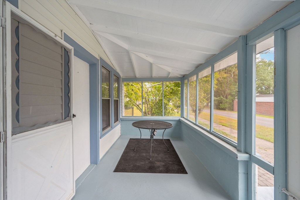 A sunny day in a room with a table and chairs.