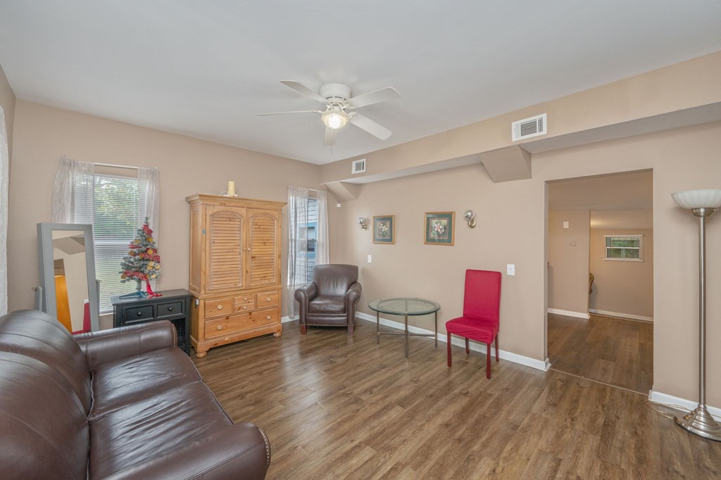 A living room with a brown leather couch and a wooden cabinet.