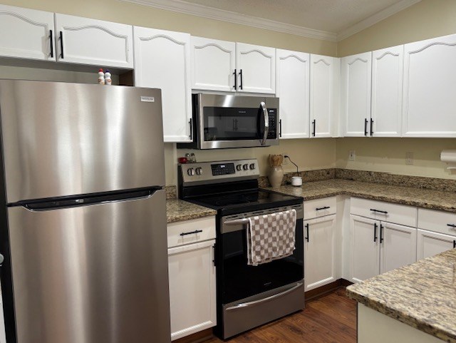 A kitchen with a stainless steel refrigerator and a black stove top oven.