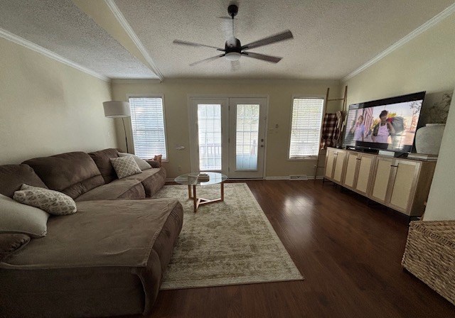 A living room with a brown couch and a ceiling fan.