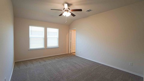 A room with a ceiling fan and carpeted floor.