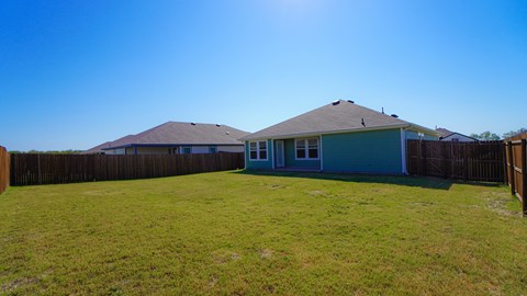 A house with a blue roof and a green lawn.