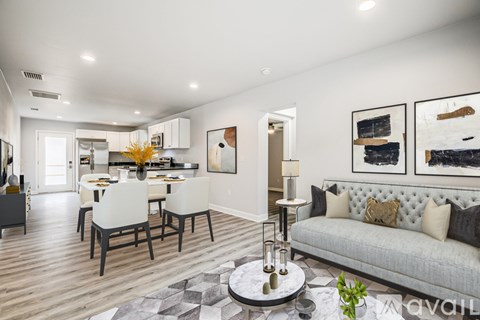 A modern living room with a grey sofa and a dining table set for four.