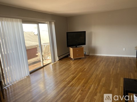 A living room with a television and sliding glass doors.
