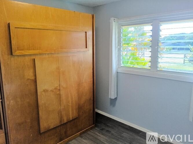 A room with a wooden door and a window with blinds.
