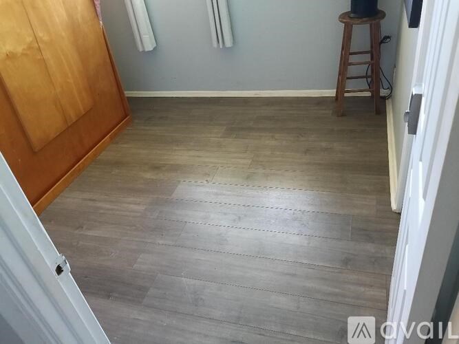 A room with wooden flooring and a wooden door.