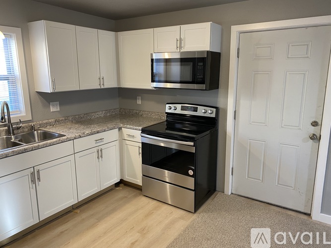 A kitchen with white cabinets and a black stove top oven.