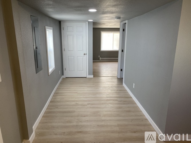 A long hallway with a white door at the end.