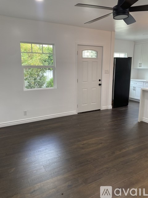 A room with a ceiling fan and wooden flooring.