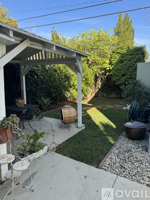A patio area with a table and chairs under a pergola.