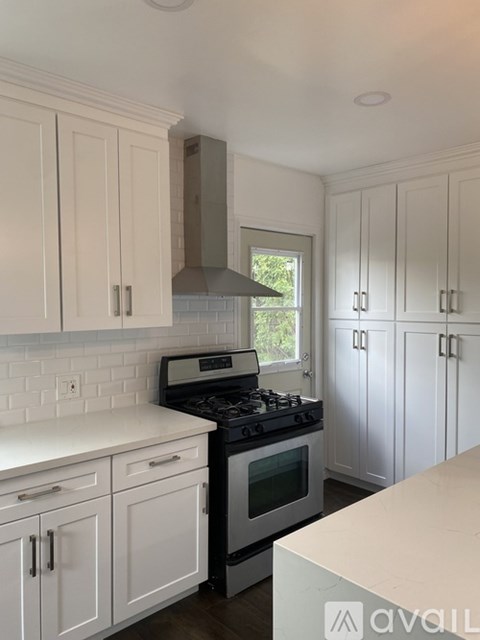A kitchen with white cabinets and a black stove top.
