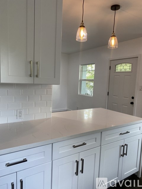 A kitchen with white cabinets and a white countertop.