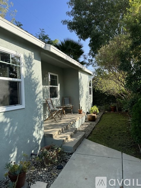 A house with a patio and a tree in the background.