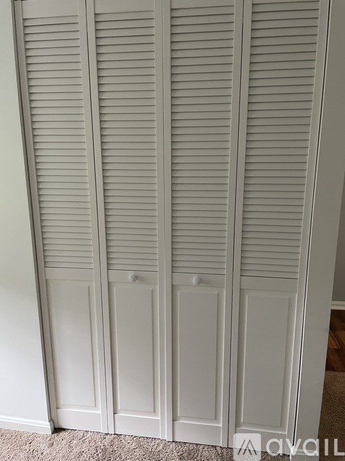 Closed white shutter doors in a room.