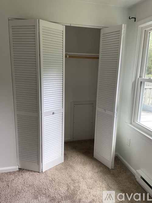 A room with a white closet and a window.