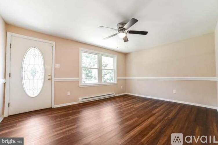 A room with a fan, a window, and a door.