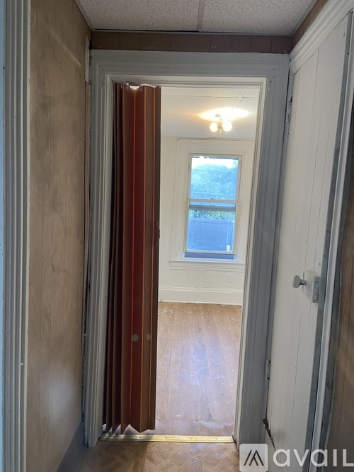 A hallway with a wooden floor and a white door.