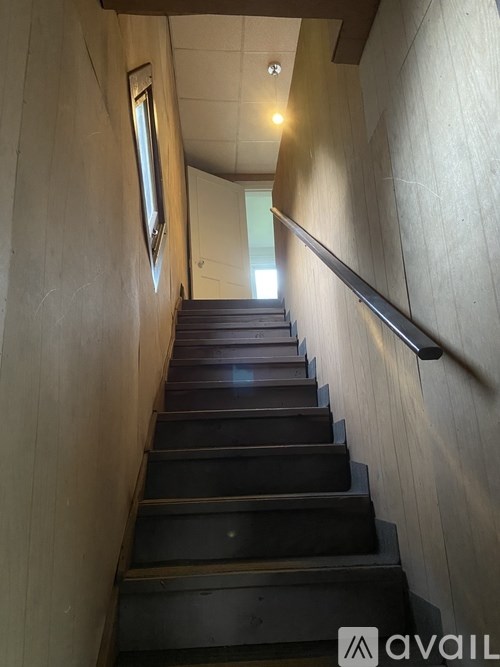 A staircase with a metal handrail on the right side.