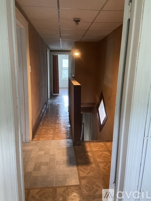 A long hallway with a tiled floor and white walls.