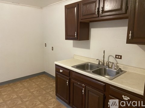 A kitchen with brown cabinets and a white sink.