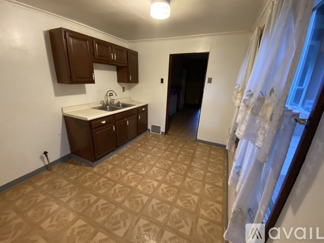 A kitchen with brown cabinets and a patterned floor.