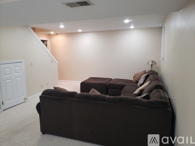 A living room with a brown couch and a white door.